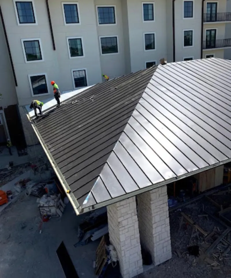 Crew installing standing seam metal roof panels on a commercial project in South Daytona